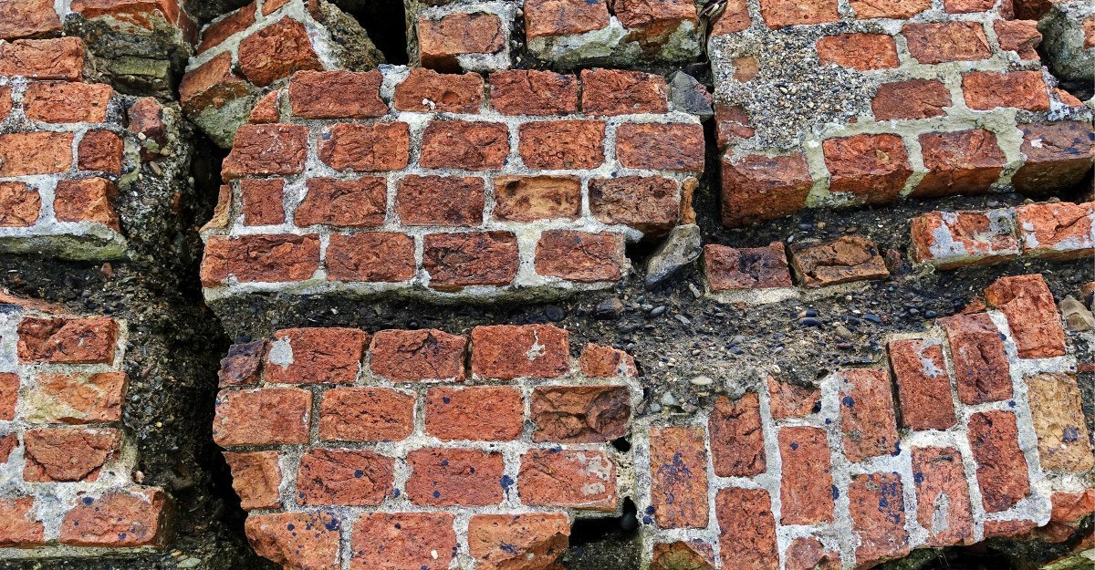 Fisuras y juntas deterioradas en un muro de ladrillo