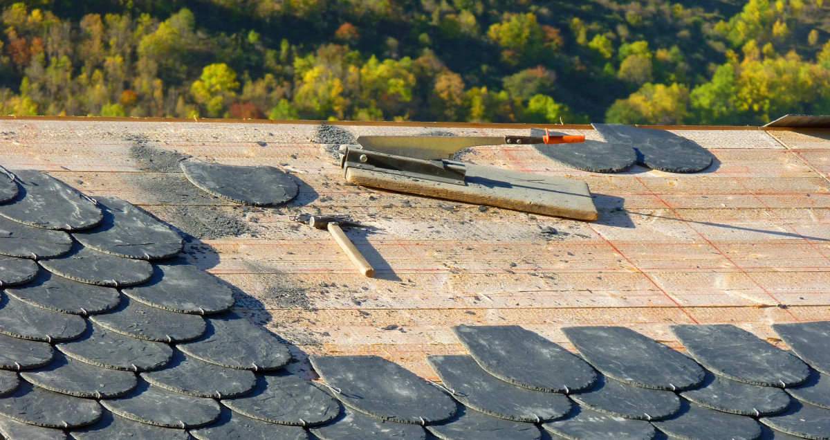 Cubierta de pizarra en construcción con herramientas sobre el soporte