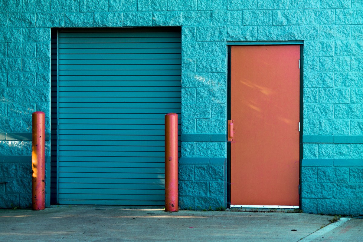 Puerta exterior a nivel de un pavimento de acceso