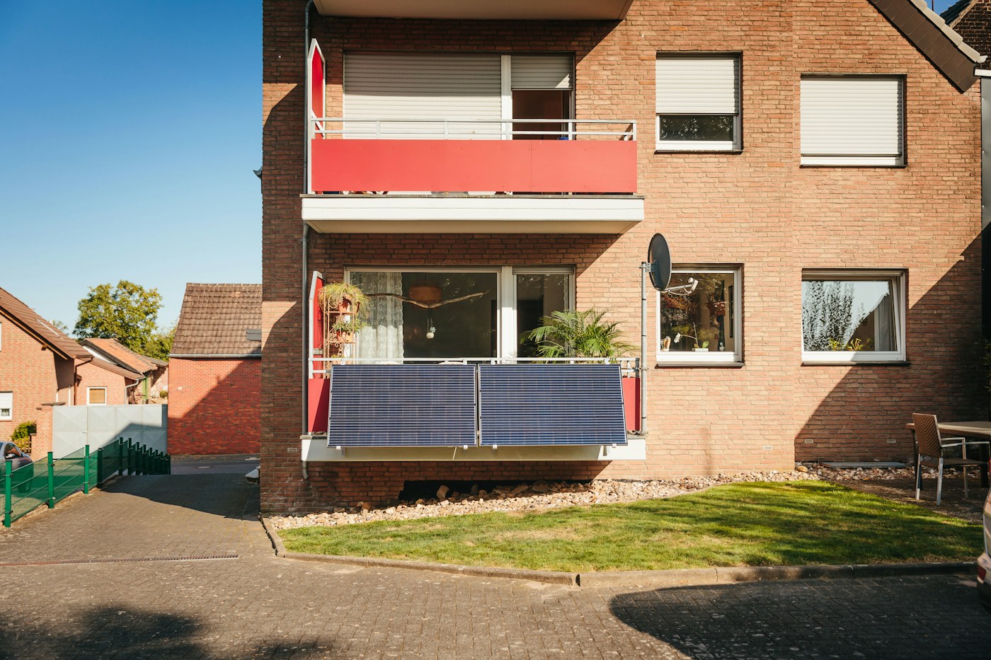 Instalación fotovoltaica en el balcón de una fachada de ladrillo
