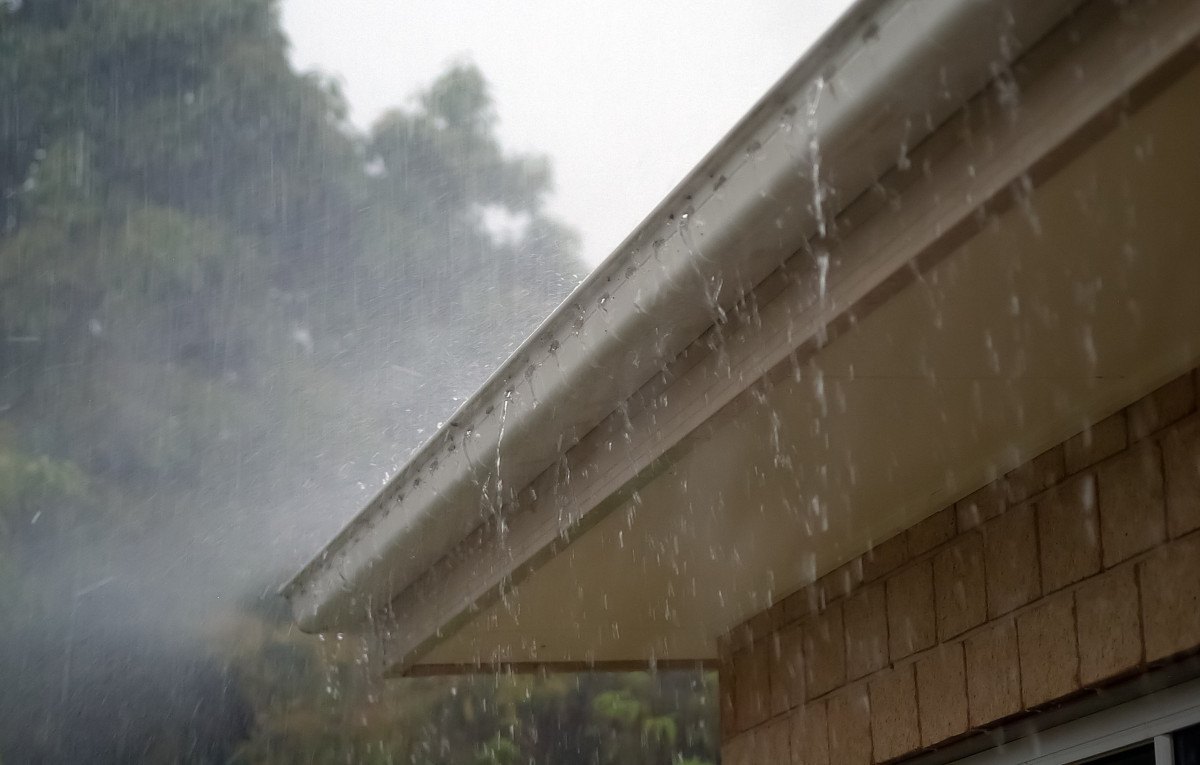 Agua de lluvia cayendo desde un alero