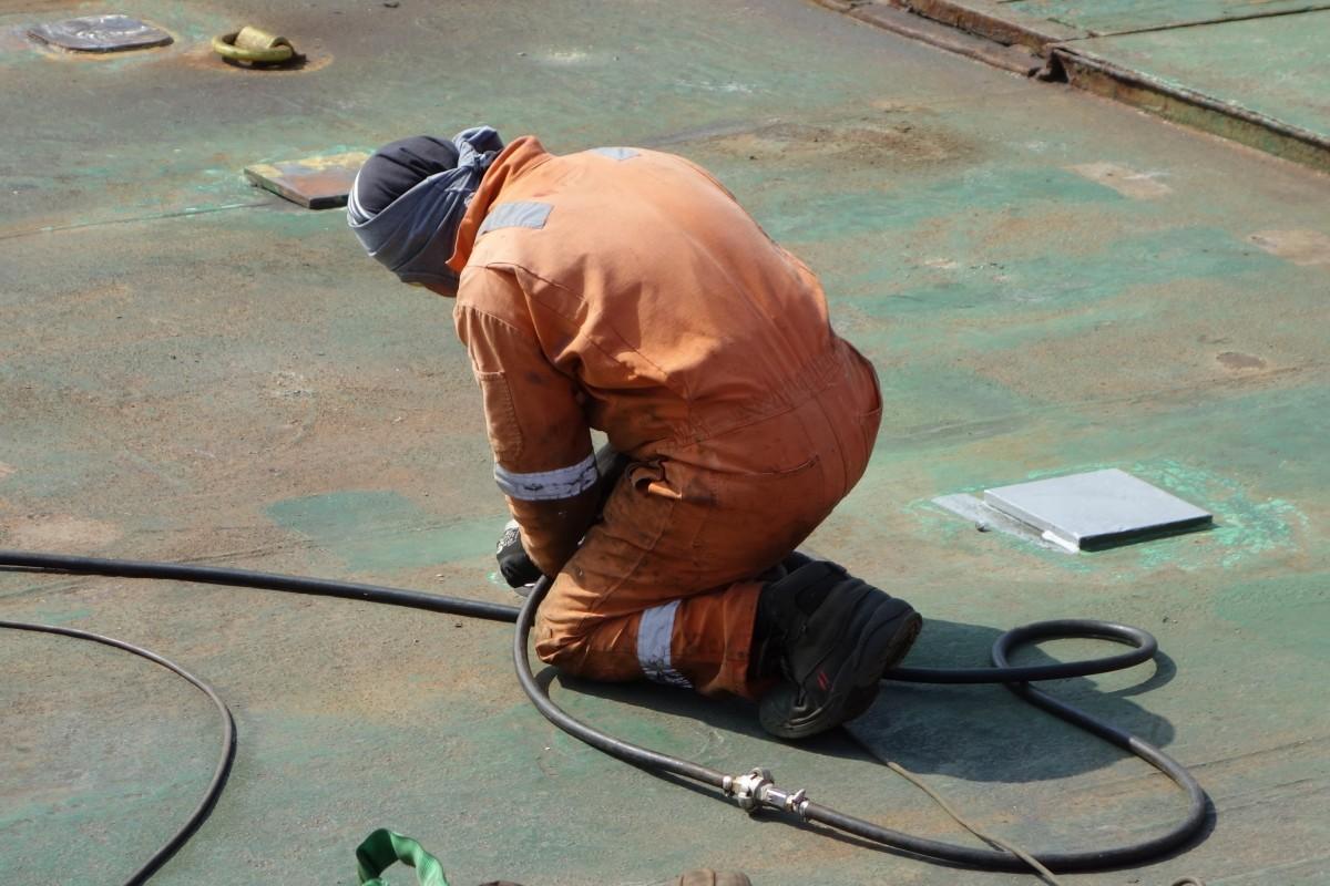 Operario con protección trabajando en una unión metálica como fotografía ilustrativa